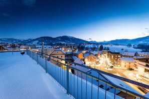 Eine verschneite Stadt mit Gebäuden und Bergen im Hintergrund.
