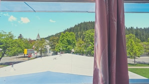 En utsikt från ett fönster med utsikt över en parkeringsplats, där en skylt visar texten ”Stardust Motel”.