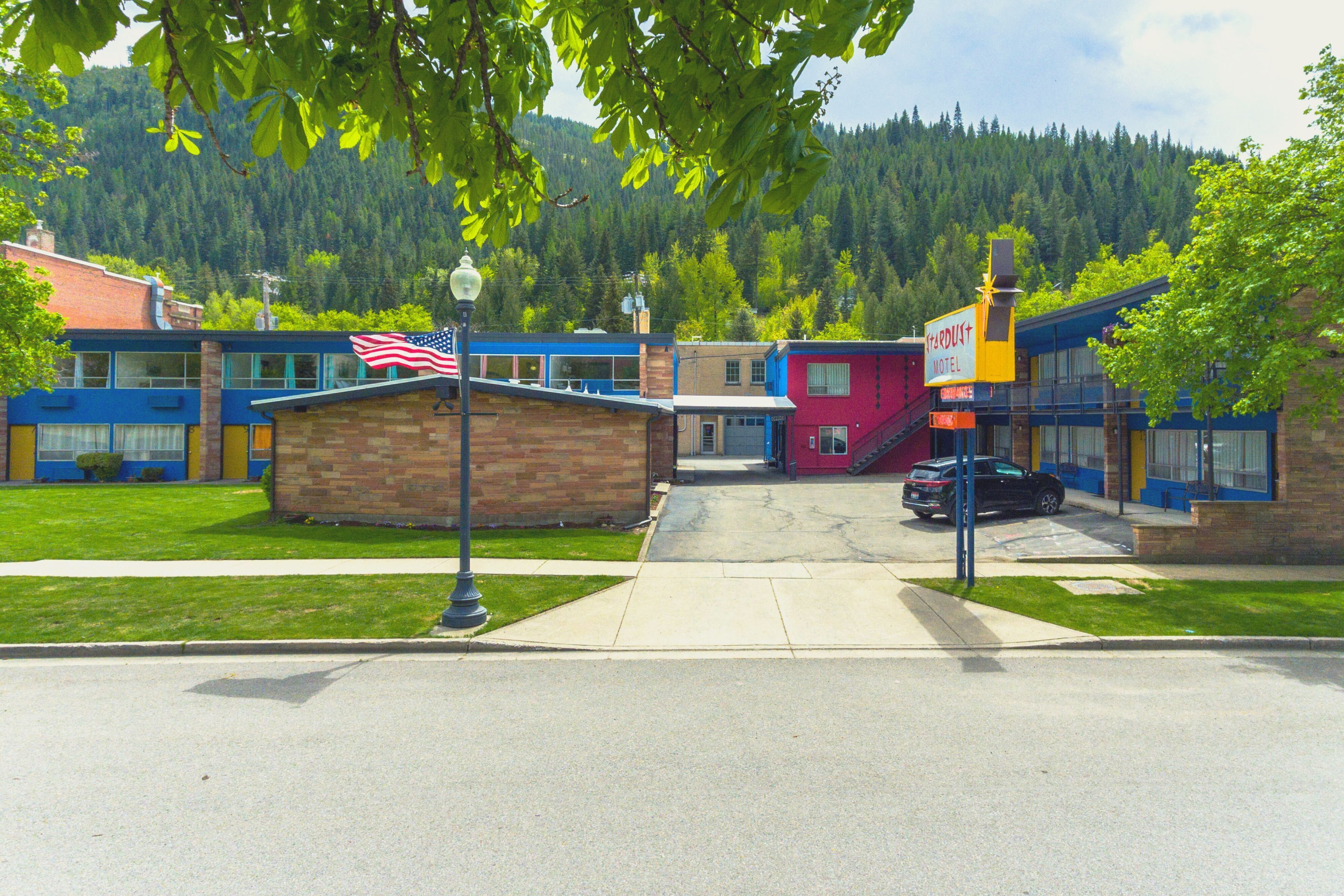 A hotel with a red exterior, a visible American flag, and a sign indicating it is a hotel.