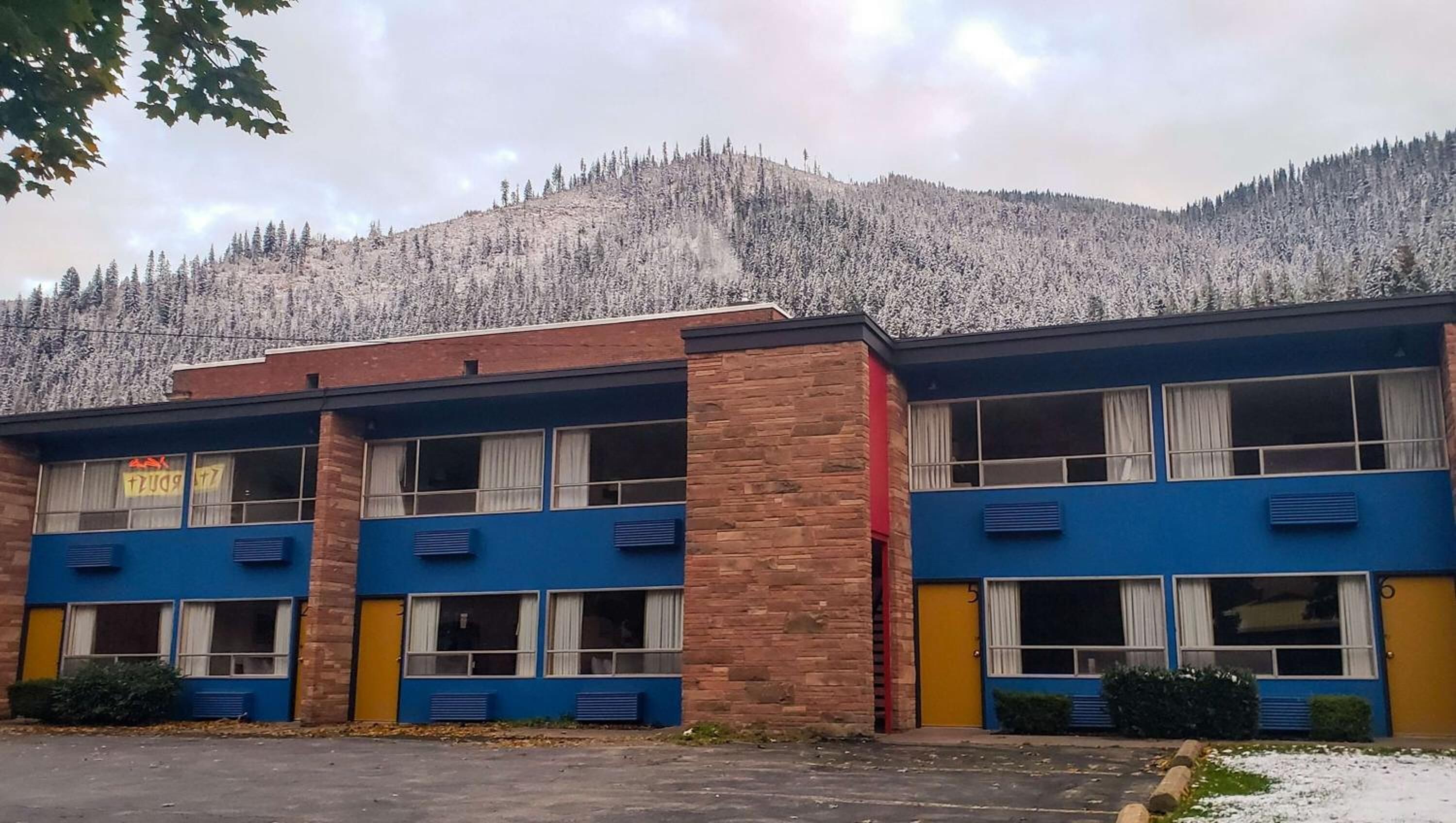 A two-story building with a brick facade and blue and yellow exterior walls.