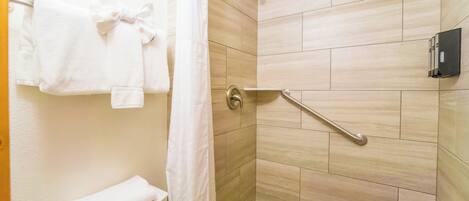 A bathroom with a shower, toilet, and towel rack.