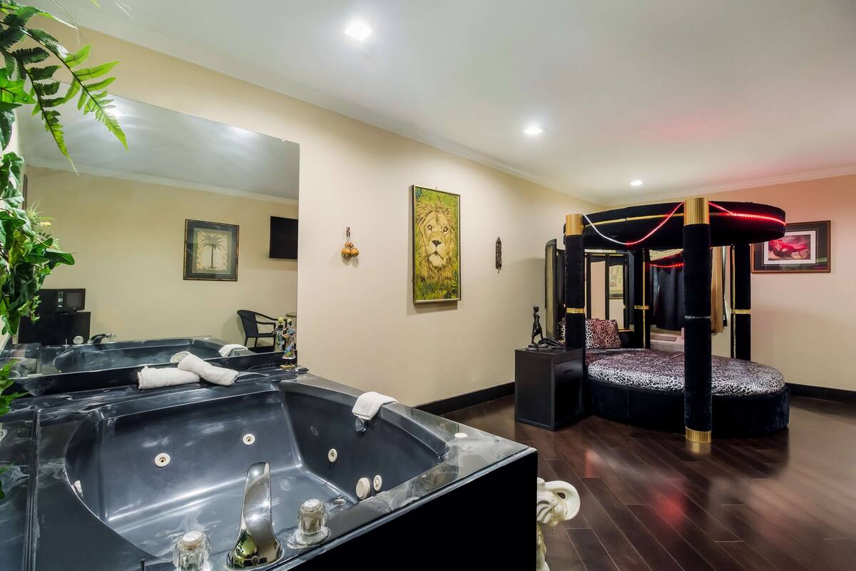 Chambre, 1 très grand lit (Jacuzzi) | Fer et planche à repasser, accès au Wi-Fi (inclus), réveille-matin