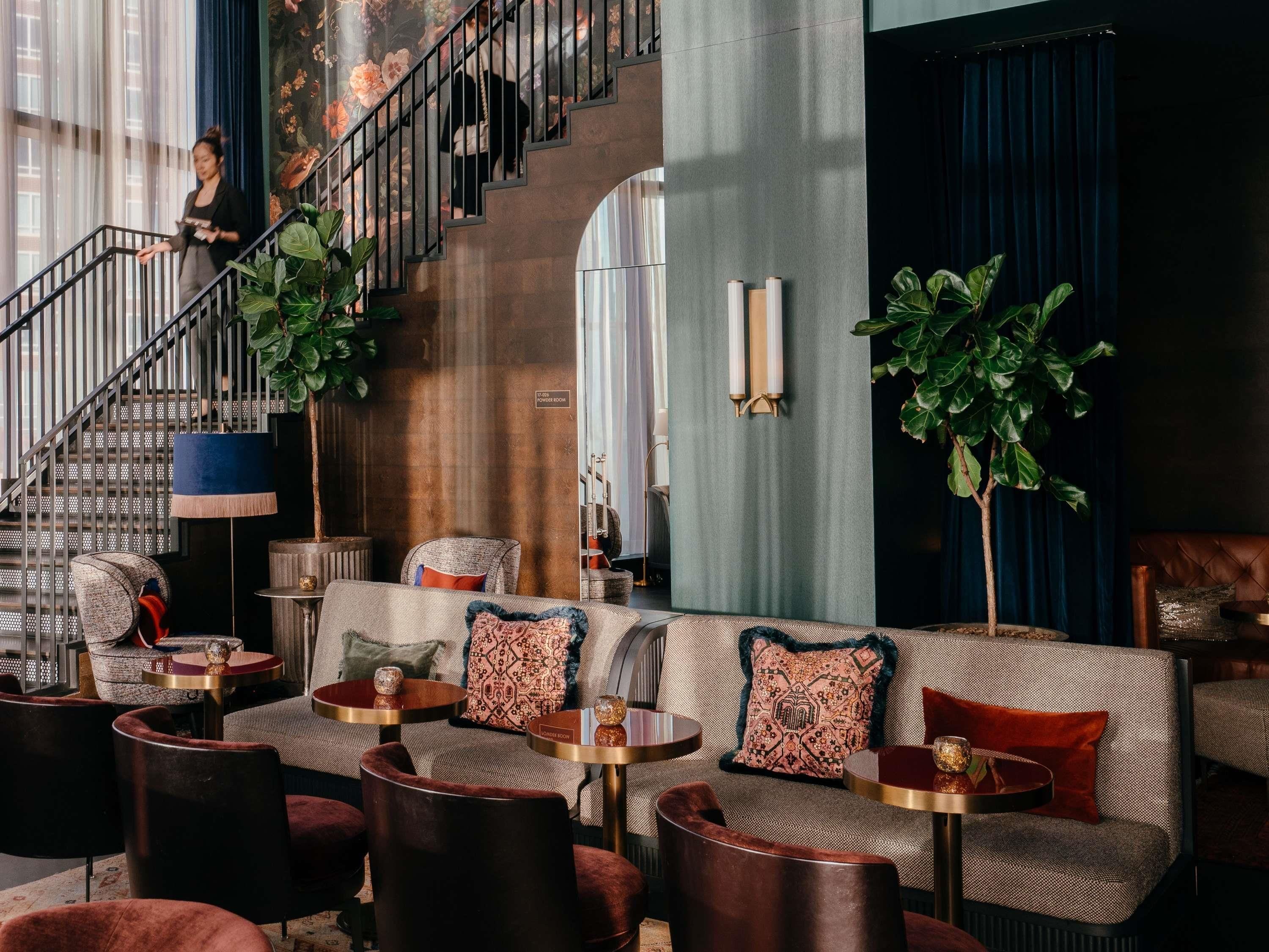A lobby with a staircase, seating area, and a powder room.