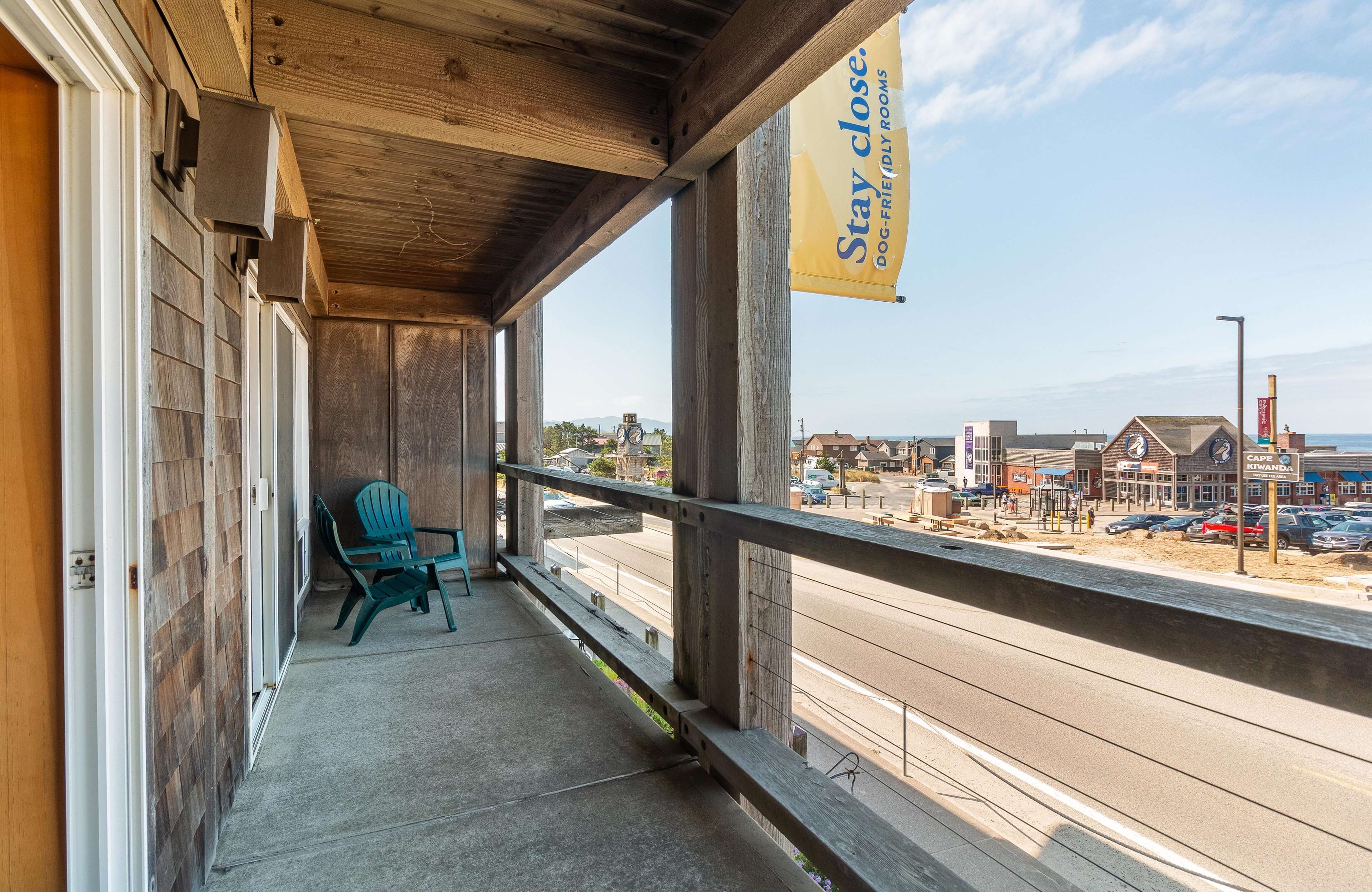 A wooden balcony with a view of a beach and town.