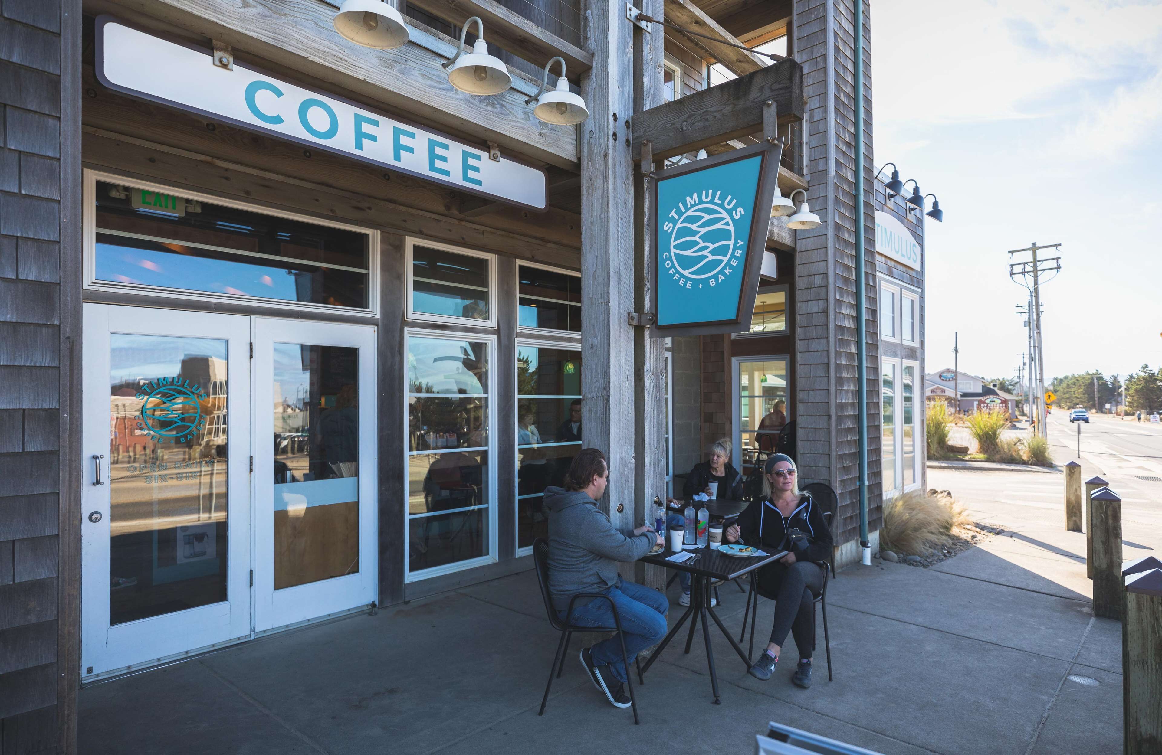 A coffee shop with outdoor seating and a sign reading "COFFEE".