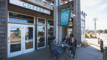 A coffee shop with outdoor seating and a sign reading "COFFEE".