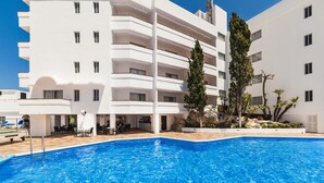 Ein modernes Hotel mit Schwimmbad, Außenbereich und einem angelegten Garten.