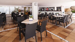Ein Restaurant mit Außenbereich, einschließlich Tischen, Stühlen und einer Bar mit einer Theke und Hockern.