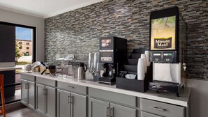 Une cuisine moderne dotée d’un espace dédié au café, comprenant une machine à café et un panneau indiquant « Minute Maid Premium ».