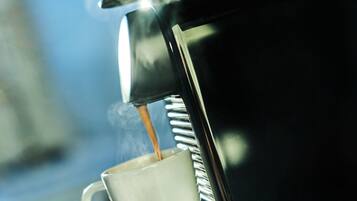 Primer plano de una cafetera sirviendo café en una taza.