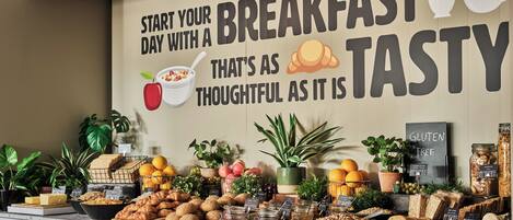 A breakfast buffet with various food items and a sign encouraging a tasty start to the day.