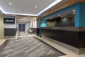 A hotel reception area with a modern design, including a reception desk, seating area, and a sign for OAKS Hotels & Resorts. - Oaks Perth Hotel (Perth)