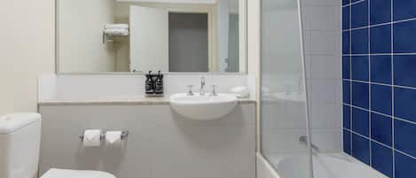 A bathroom with a toilet, sink, and shower.