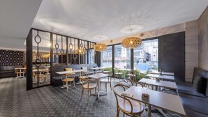 A modern cafe with wooden furniture, large windows, and decorative lighting. - Oaks Perth Hotel (Perth)
