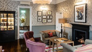 Una sala de estar acogedora con chimenea, estantería y zona de estar confortable.