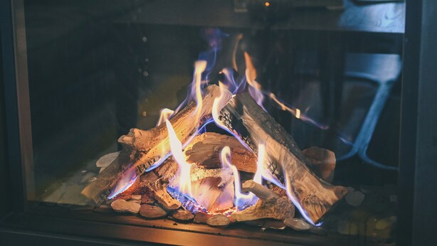 A fireplace with logs and flames. - Didsbury House Hotel (Manchester)