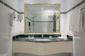 Bathroom features a large mirror, white vanity, and a hairdryer for convenience.