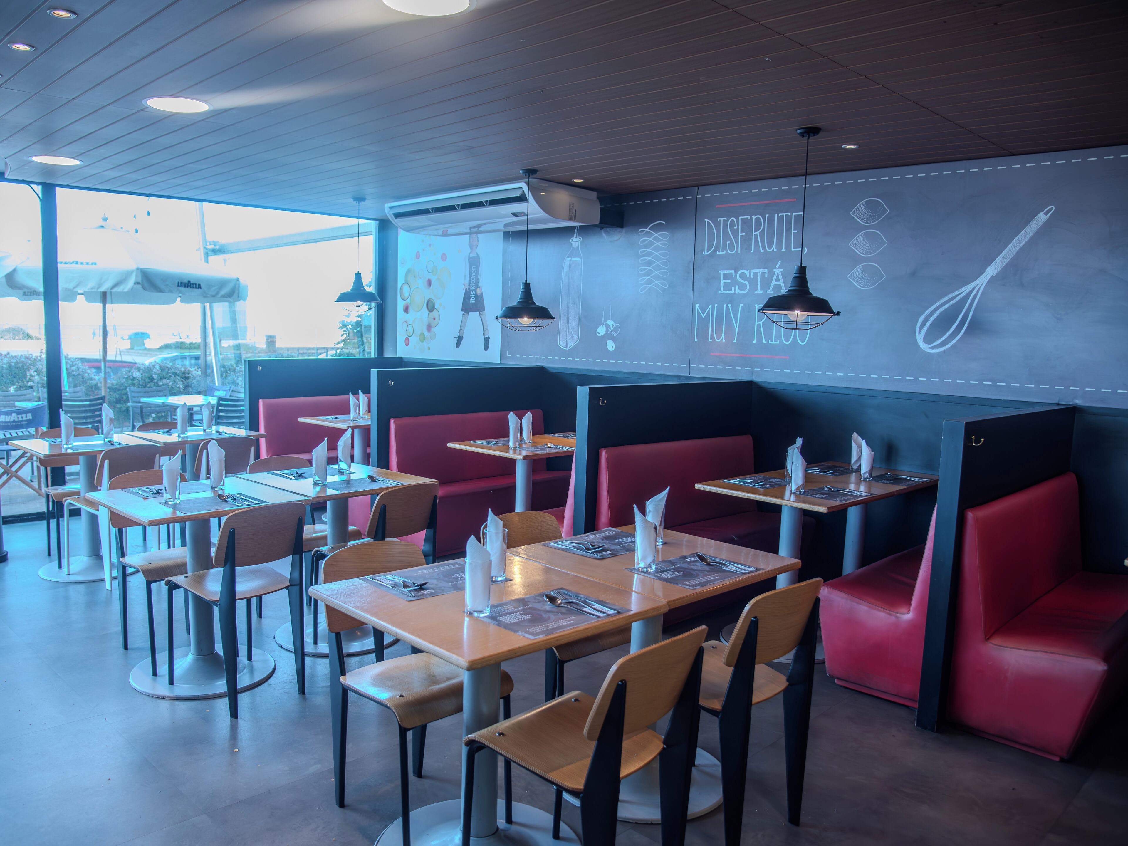 Un restaurante con cabinas y mesas, algunas con menús y servilletas.