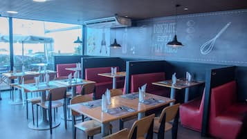 Un restaurante con cabinas y mesas, algunas con menús y servilletas.