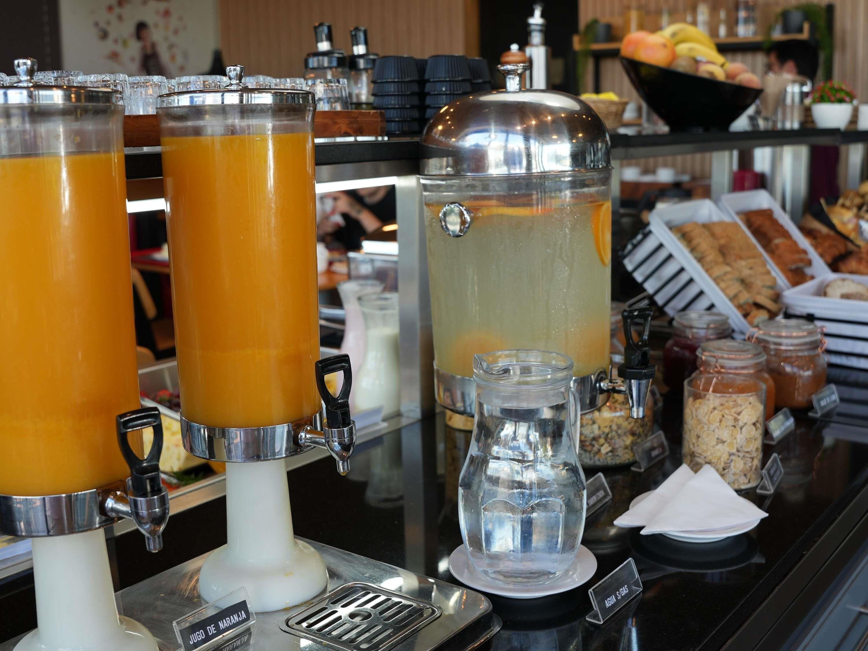 Um buffet de café da manhã com diversas bebidas e alimentos.