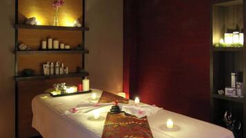 Experience relaxation in this serene spa room, featuring a central massage table, spa products, and a peaceful ambiance.