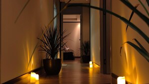 A hallway with potted plants and candles, leading to a room with a bed and a window. - Novotel World Trade Centre (Dubai)