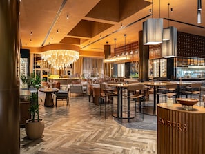 A modern restaurant with a warm interior, wooden flooring, and a bar area. - Novotel World Trade Centre (Dubai)