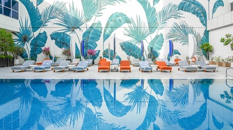 Una piscina al aire libre, sombrillas, sillones reclinables de piscina. Novotel World Trade Centre