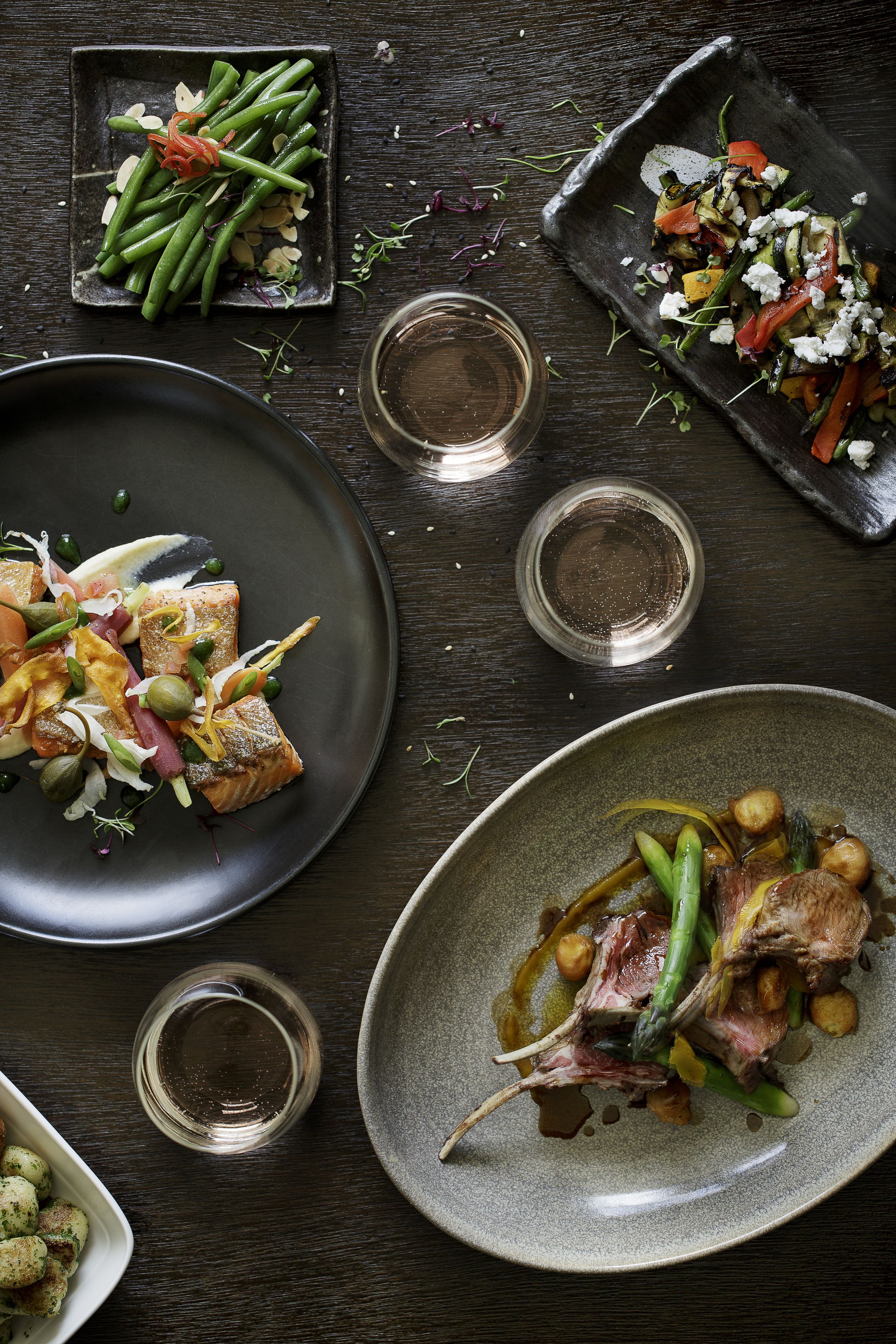 A dining table with various dishes, including a plate of salmon, a plate of green beans, and a plate of vegetables.