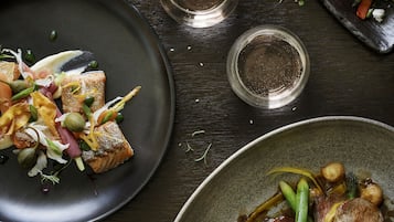 A dining table with various dishes, including a plate of salmon, a plate of green beans, and a plate of vegetables.