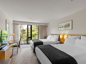 A hotel room with two beds, a desk, a chair, a TV, and a balcony with curtains. - Novotel Queenstown Lakeside (Queenstown)