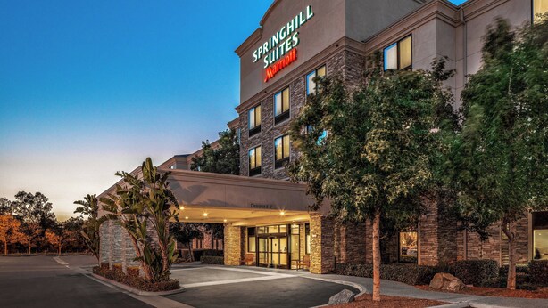 A hotel with a stone facade, a covered entrance, and a sign reading "Springhill Suites Marriott".