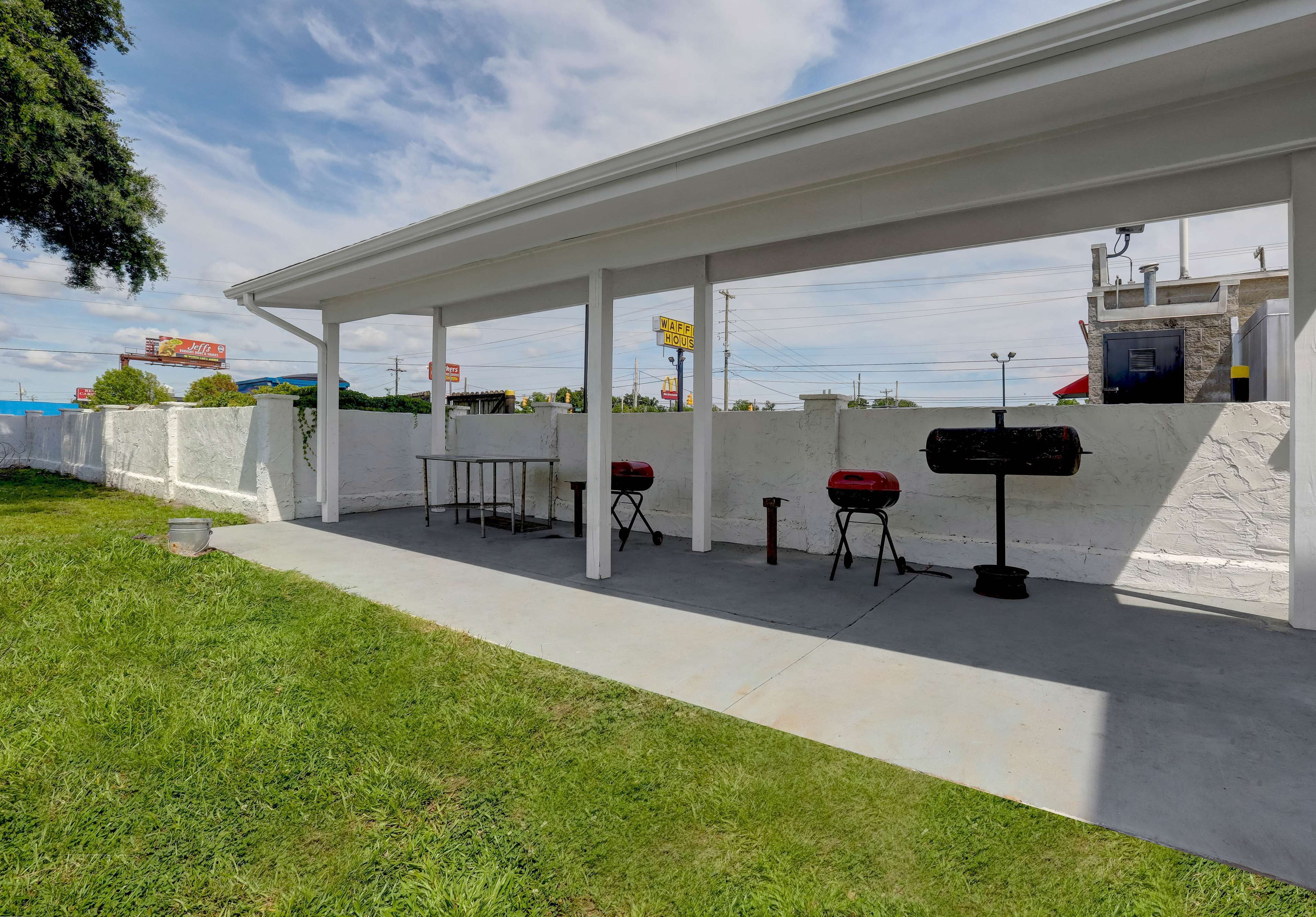 Een overdekt buitengebied met barbecues en een waterfontein.