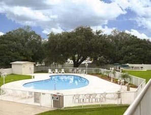 Una piscina al aire libre de temporada, sillones reclinables de piscina