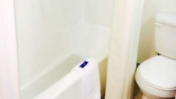 A bathroom with a bathtub, toilet, and a shower curtain.