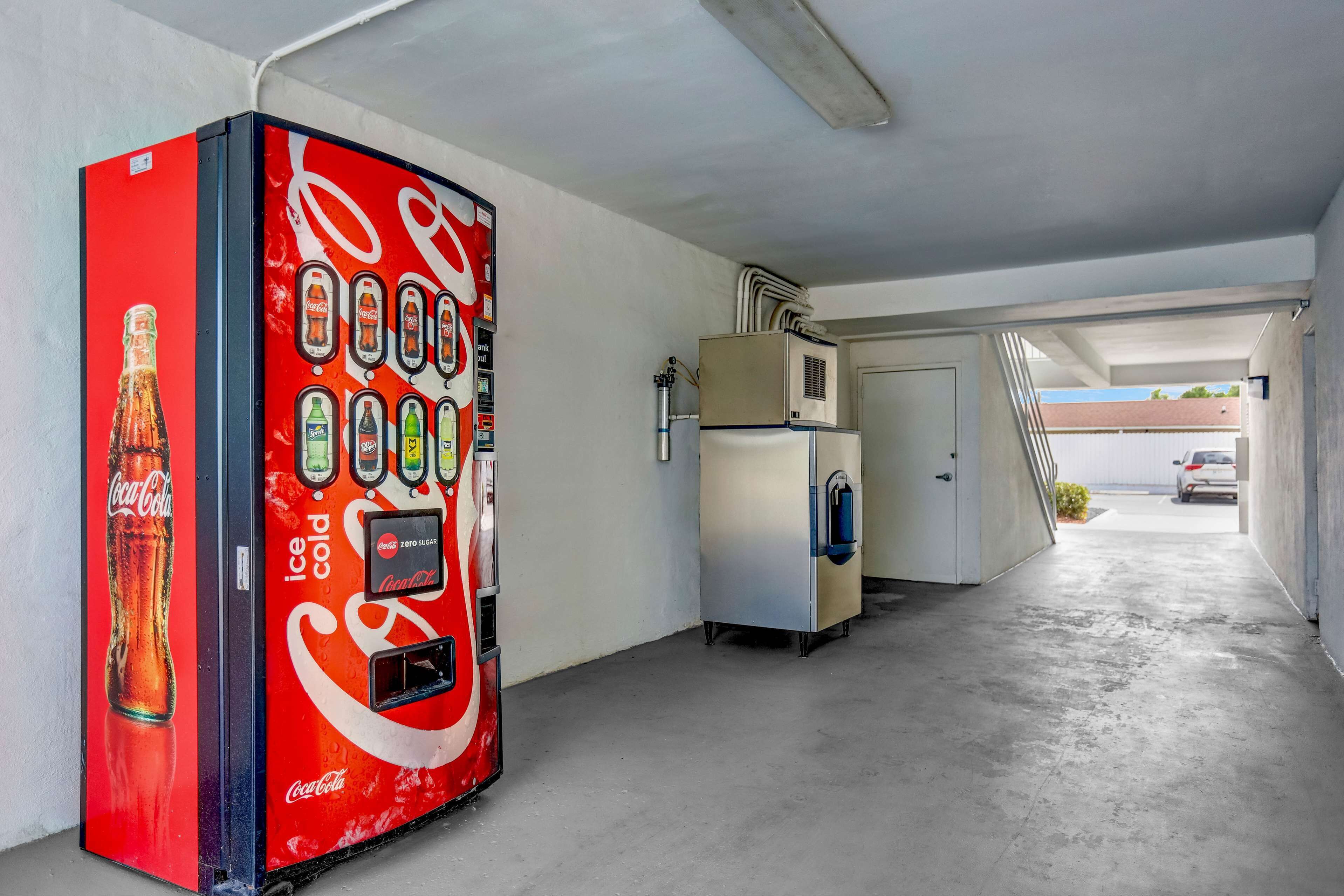 A Coca-Cola vending machine in a parking garage.