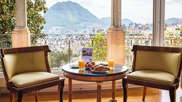 A dining area with two chairs and a table, a plate of food, and two glasses of orange juice.