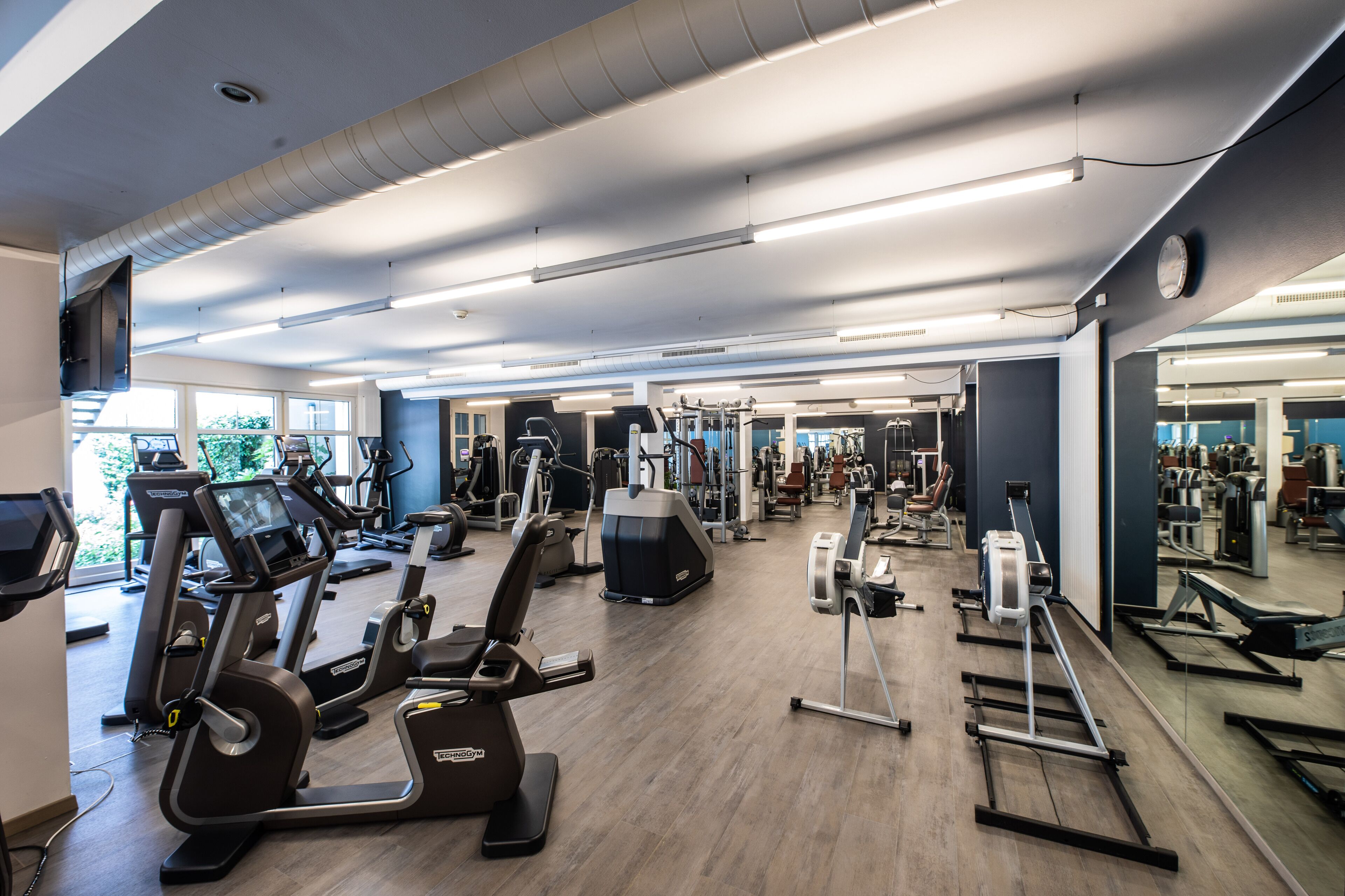 A gym with treadmills, elliptical machines, and weight machines.