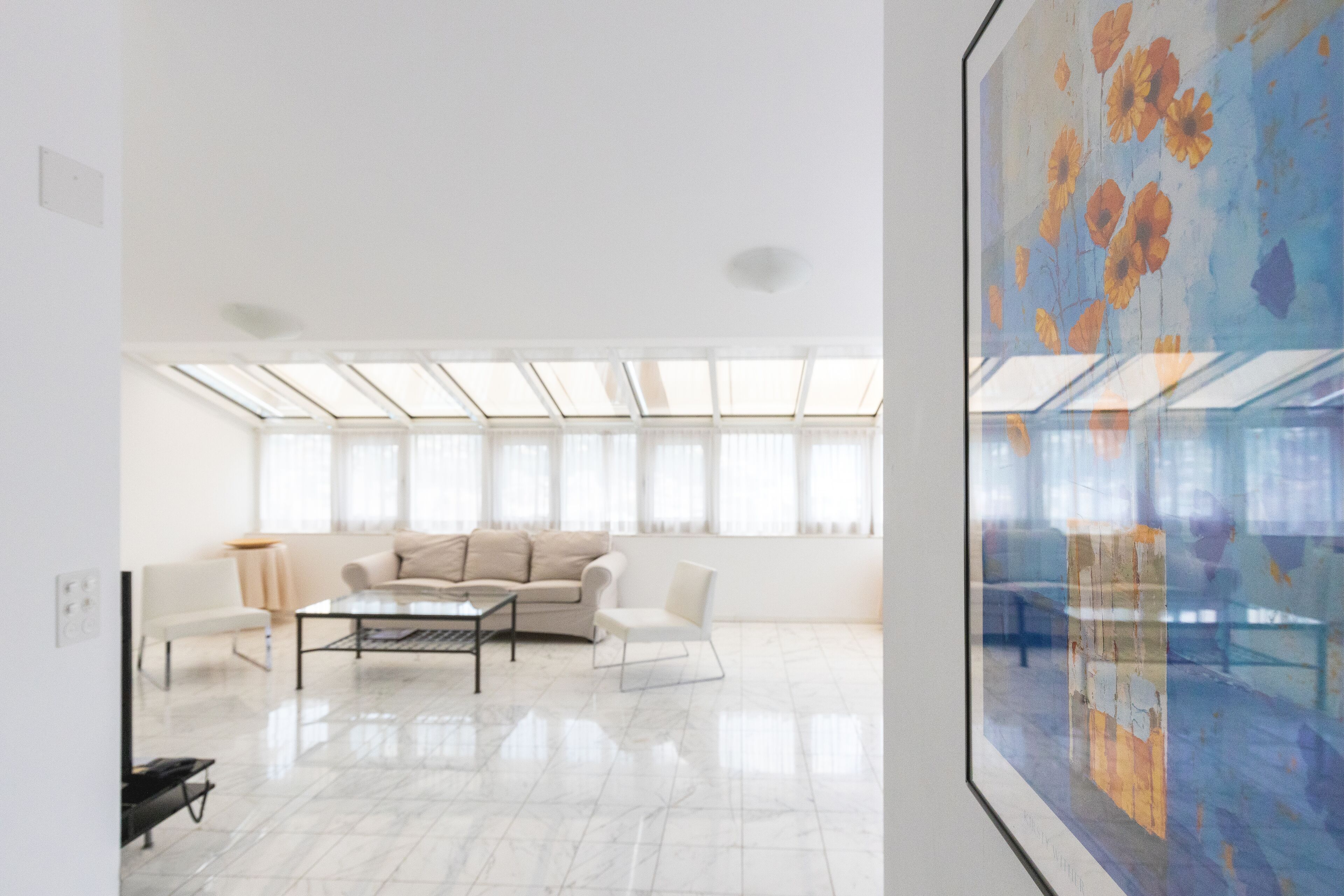 A modern living room with a sofa, coffee table, and a large window.