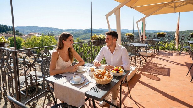 A couple dining at an outdoor table with a view of the countryside. - Palazzo Leopoldo Dimora Storica & Spa (Radda in Chianti)