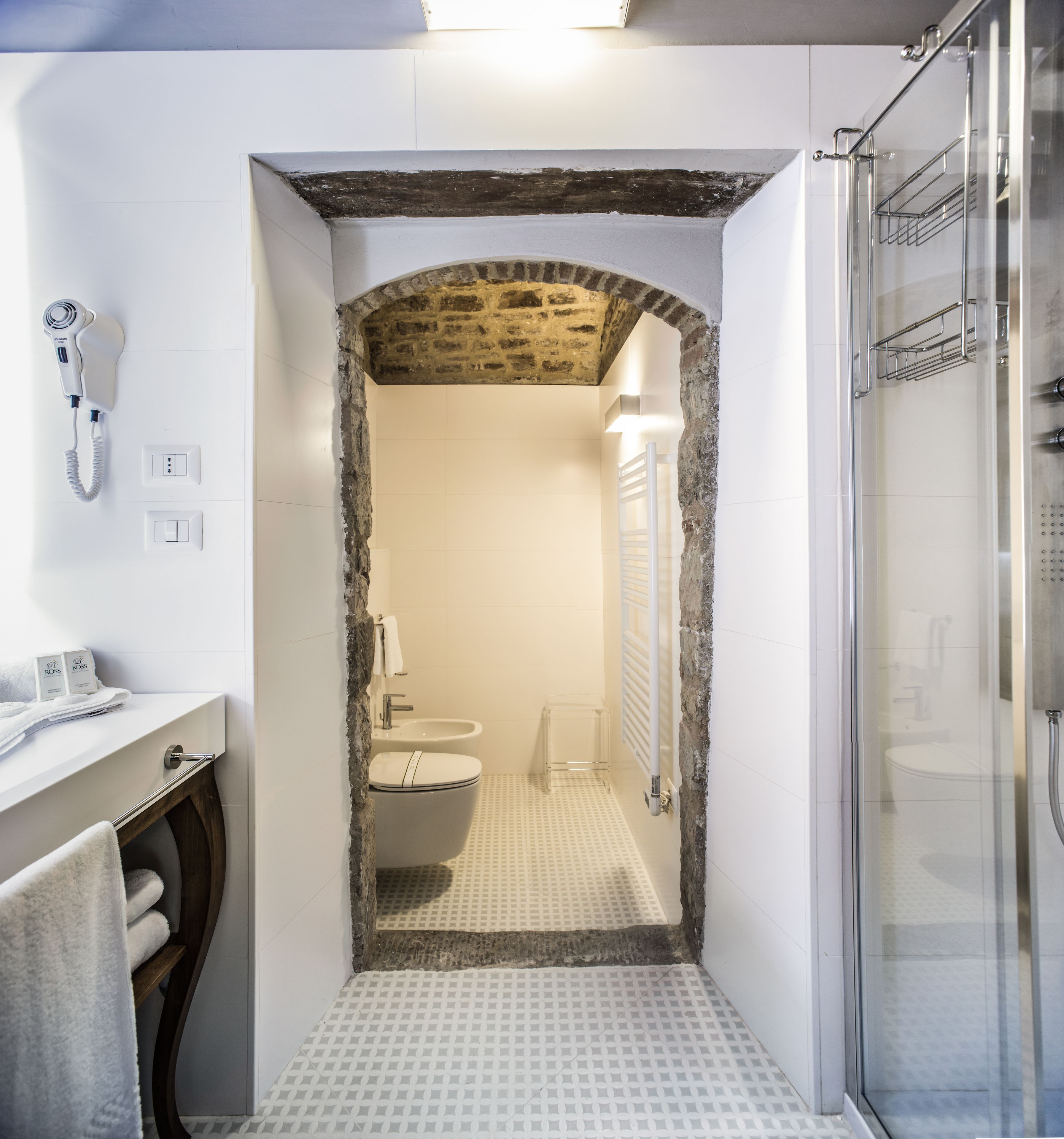 A bathroom with a white sink, a toilet, and a shower area.