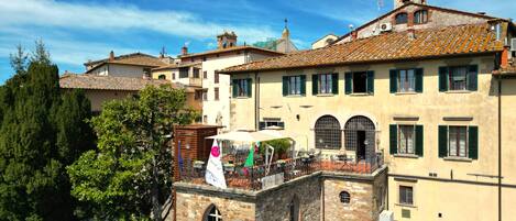 A historic building with multiple stories, stone walls, and a tiled roof.