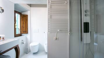 Ein modernes Badezimmer mit Duschkabine aus Glas, einer weißen Toilette, einem Holzschrank und einem Handtuchhalter.