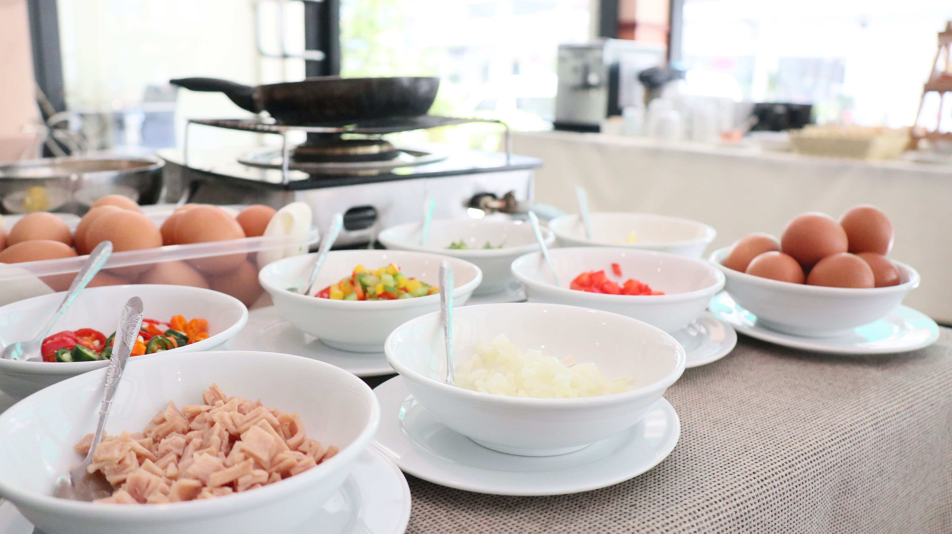 A buffet table with various food items and utensils.