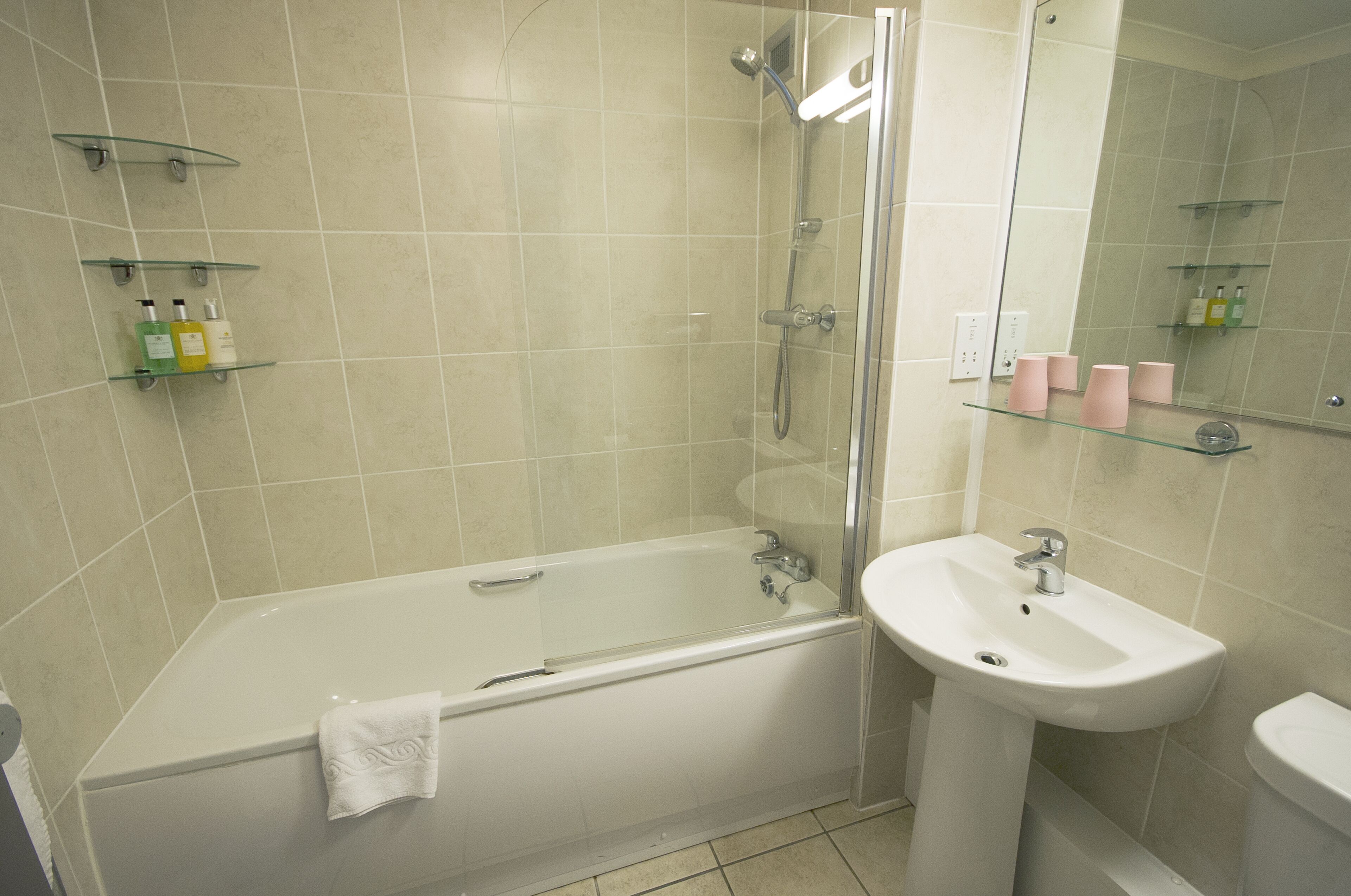 Un baño moderno con bañera, lavamanos y cabina de ducha de vidrio.