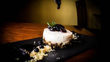A dessert on a black slate plate with a dark background.