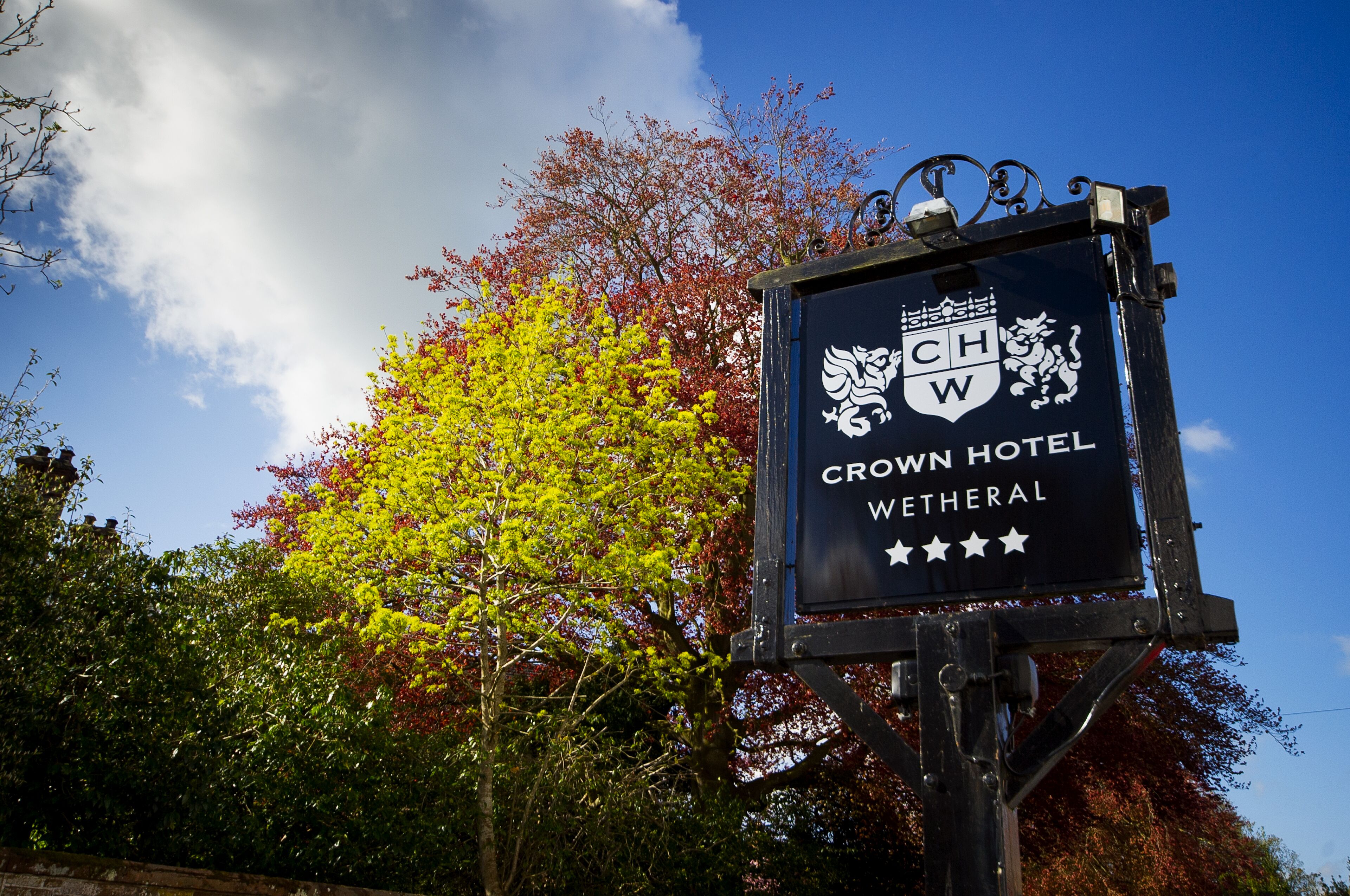 A sign for the Crown Hotel Wetheral with a crest and four stars.