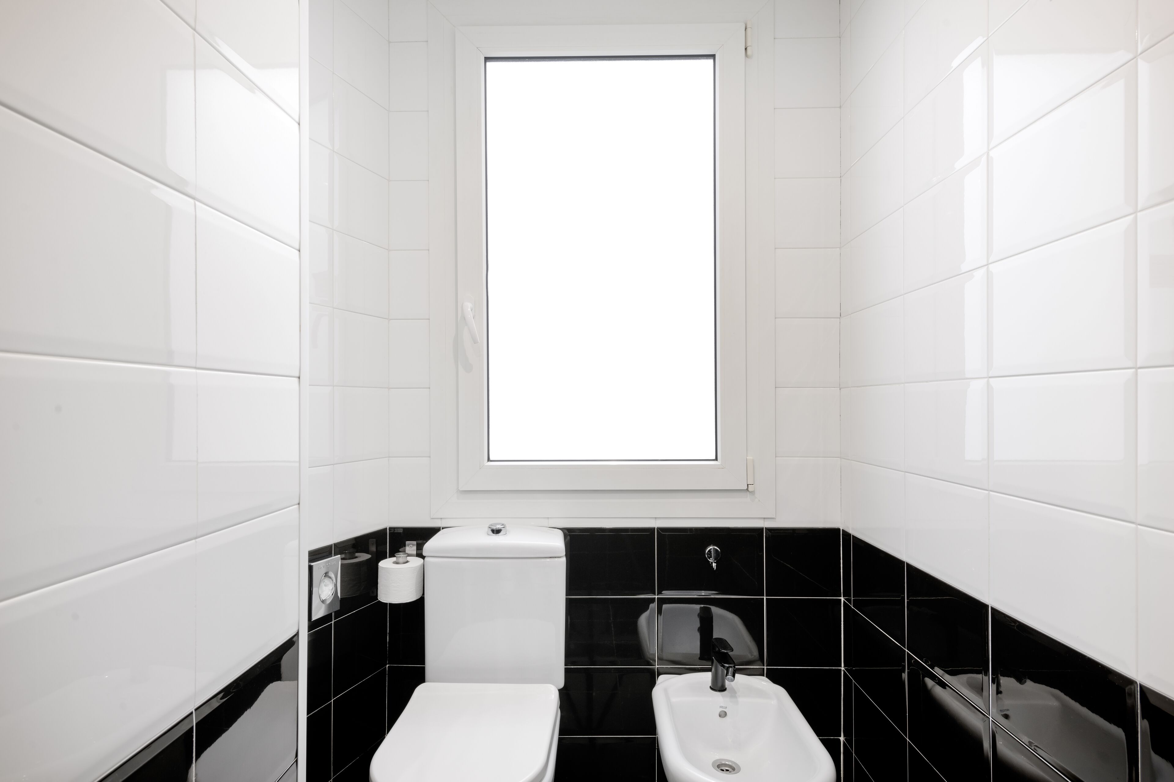 Un baño con inodoro, lavabo y ventana.