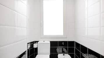 Un baño con inodoro, lavabo y ventana.