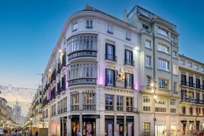 Un hotel histórico con un estilo arquitectónico clásico europeo, que cuenta con varios balcones y ventanas amplias.